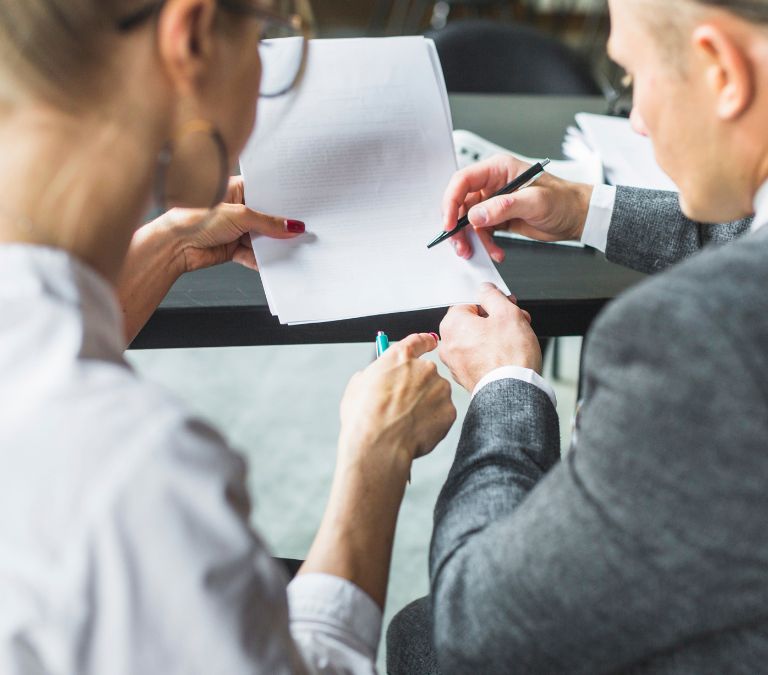 Un asesor y una empresaria firmando un contrato